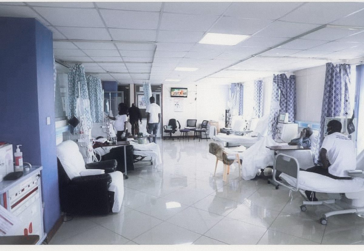 Bright dialysis floor with recliners, machines and blue privacy curtains
